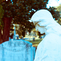 A marble statue on a gravestone marker.