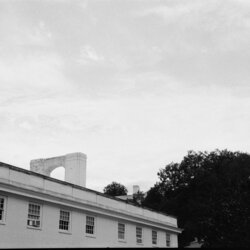 A building in front of a sky filled with wisps of clouds.